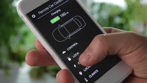 L'uomo controlla il livello di carica della sua auto elettrica. La batteria è carica. Telecomando auto utilizzando l'interfaccia immaginaria dell'applicazione smartphone . — Video Stock