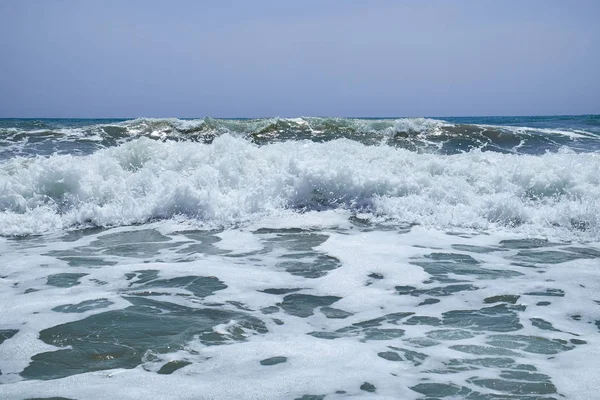 The surging waves of the Mediterranean on the beautiful beach Valencia in the summer sunny day. — Stock Photo, Image