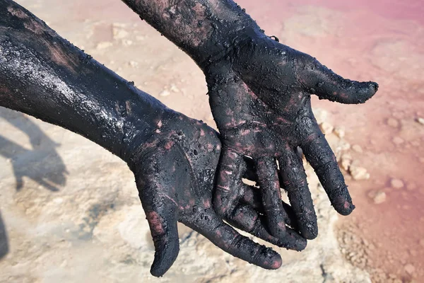 Eller erkek siyah çamur bulaşmış. Yakın çekim. Göl Las Salinas adlı Torrevieja. İspanya.