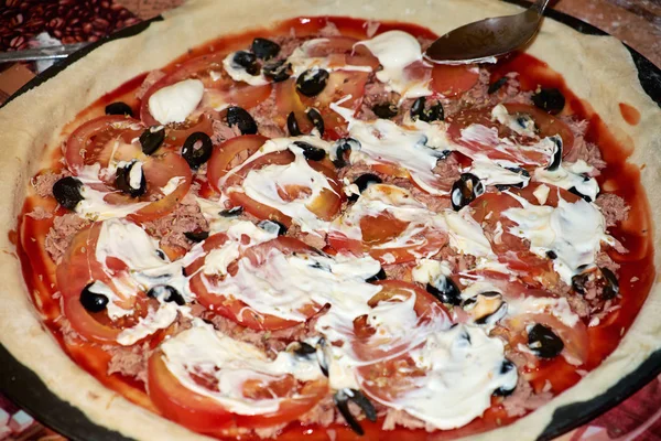 Domates, zeytin, mayonez ve et lezzetli pizza pişirme.