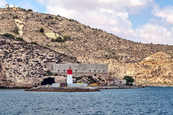 Röd och vit fyr nära fortet av jul och hamnen. Cartagena, Spanien. — Stockfoto