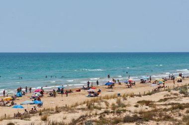 Valencia, İspanya - 6 Temmuz 2015: sahilde turistler ve yerliler için rahatla. Arka planda dağlar