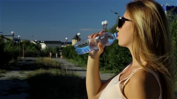 Jonge mooie meisje mineraalwater drinken — Stockvideo