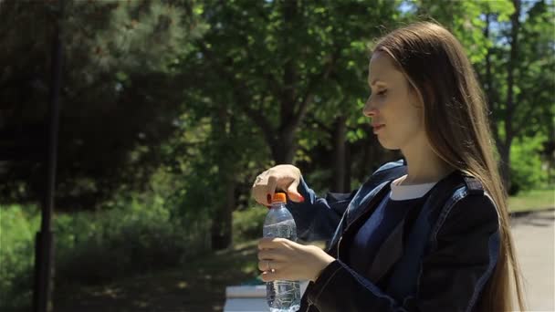 Гарненька молода жінка п'є джерельну воду — стокове відео