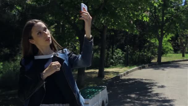 Attrayant jeune fille avec smartphone, en plein air — Video