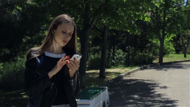 Attrayant jeune fille avec smartphone, en plein air — Video