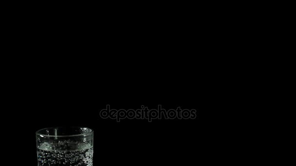 Eau minérale fraîche dans un verre sur fond noir 