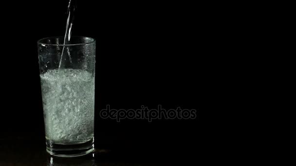 Eau minérale fraîche dans un verre sur fond noir 