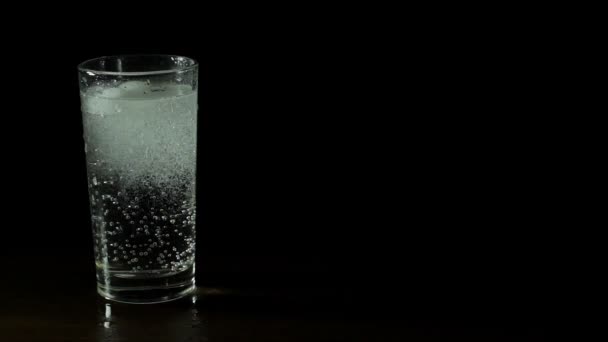 Acqua minerale fresca in un bicchiere su fondo nero — Video Stock
