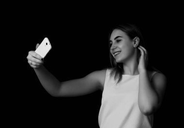 Güzel kız yapar selfie siyah arka plan gri tonlama