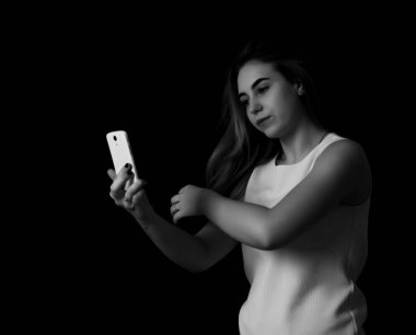 Güzel kız yapar selfie siyah arka plan gri tonlama