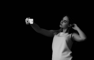 Güzel kız yapar selfie siyah arka plan gri tonlama
