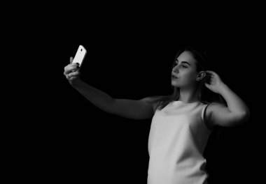Güzel kız yapar selfie siyah arka plan gri tonlama