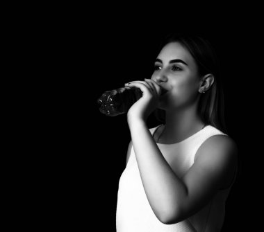 Genç güzel kadın içecekler su gri tonlama