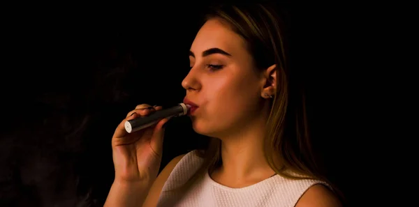 Красивая девушка использует электронную сигарету — стоковое фото