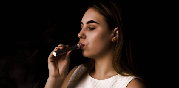 Pretty young girl uses electronic cigarette — Stock Photo, Image