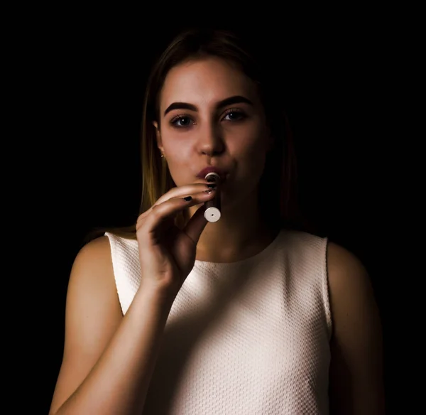 Pretty young girl uses electronic cigarette — Stock Photo, Image