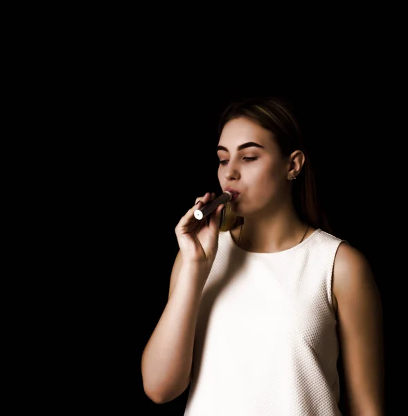 Pretty young girl uses electronic cigarette — Stock Photo, Image