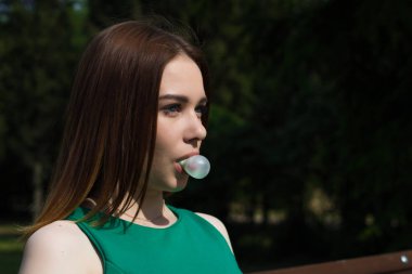 Genç güzel kız açık bir sakız çiğniyor