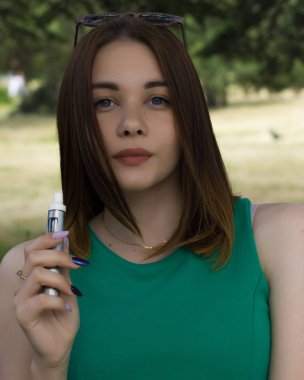 Genç güzel kadın elektronik sigara içiyor