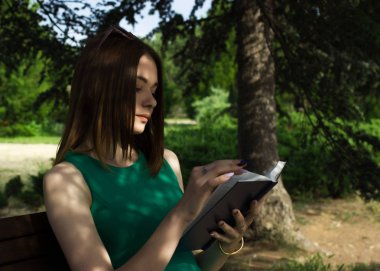 Genç güzel kız açık bir kitap okur