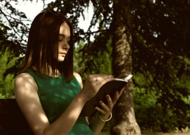Genç güzel kız açık bir kitap okur
