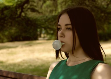 Genç güzel kız açık bir sakız çiğniyor