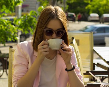 Genç güzel kız sıcak içecek, açık bir fincan içecekler