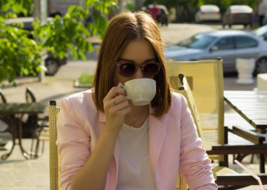 Genç güzel kız sıcak içecek, açık bir fincan içecekler