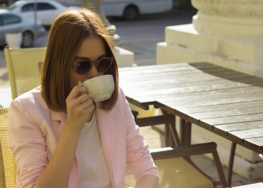 Genç güzel kız sıcak içecek, açık bir fincan içecekler