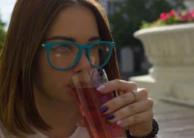 Genç güzel kız içecekler soğuk bir içecek, açık