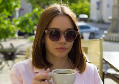 Genç güzel kız sıcak içecek, açık bir fincan içecekler