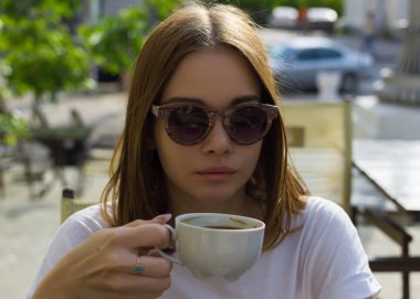 Genç güzel kız sıcak içecek, açık bir fincan içecekler