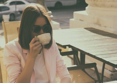 Genç güzel kız sıcak içecek, açık bir fincan içecekler