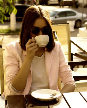 Genç güzel kız sıcak içecek, açık bir fincan içecekler