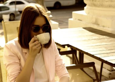 Genç güzel kız sıcak içecek, açık bir fincan içecekler