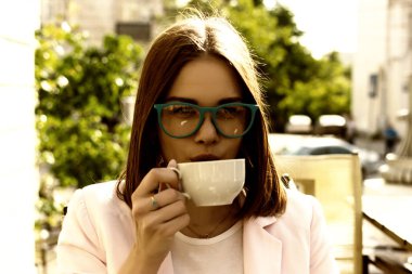 Genç güzel kız sıcak içecek, açık bir fincan içecekler