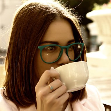 Genç güzel kız sıcak içecek, açık bir fincan içecekler