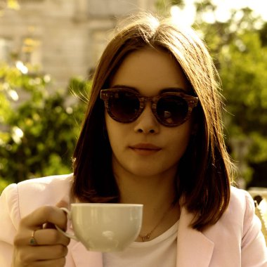 Genç güzel kız sıcak içecek, açık bir fincan içecekler