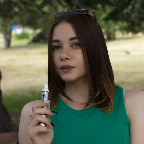 Young pretty woman smokes electronic cigarette — Stock Photo, Image