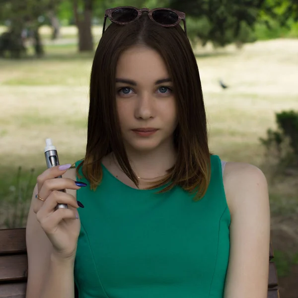 Young pretty woman smokes electronic cigarette — Stock Photo, Image