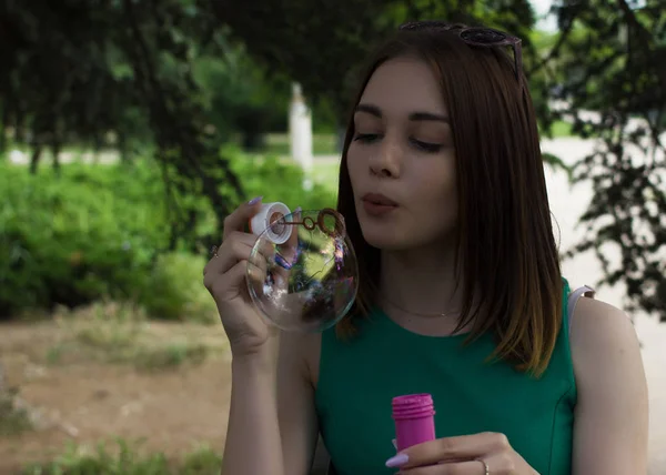 Young pretty girl blows bubbles, outdoor — Stock Photo, Image