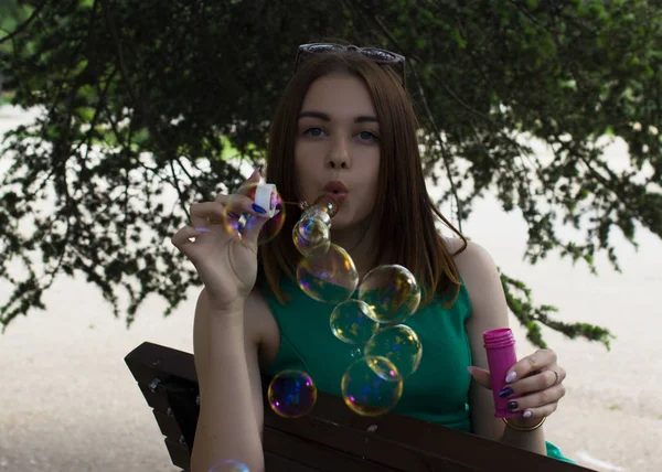 Young pretty girl blows bubbles, outdoor — Stock Photo, Image