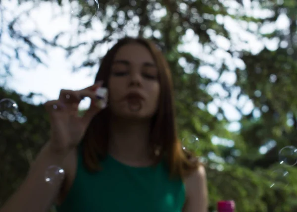 Jovem menina bonita sopra bolhas, ao ar livre — Fotografia de Stock