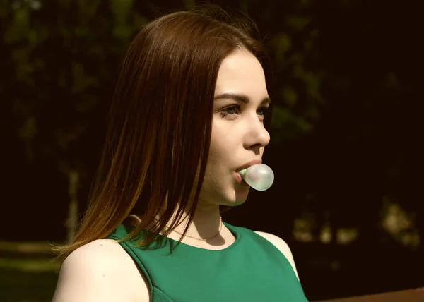 Joven chica bonita mastica un chicle, al aire libre — Foto de Stock