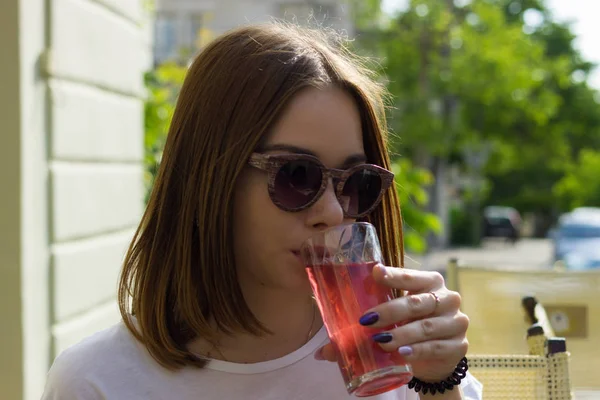 Menina bonita nova bebe uma bebida fria, ao ar livre — Fotografia de Stock