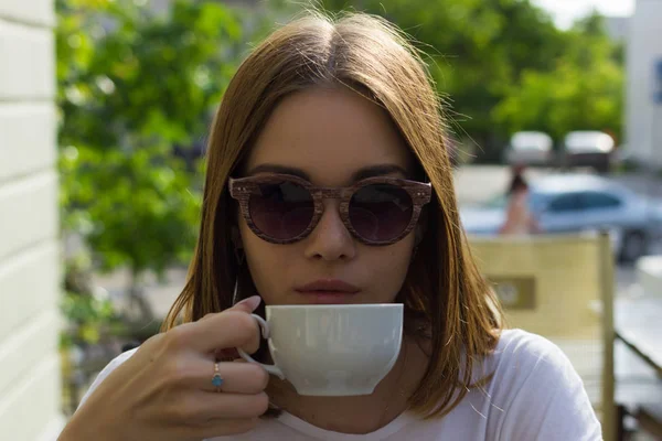 Menina bonita nova bebe uma xícara de bebida quente, ao ar livre — Fotografia de Stock