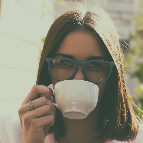 Genç güzel kız sıcak içecek, açık bir fincan içecekler