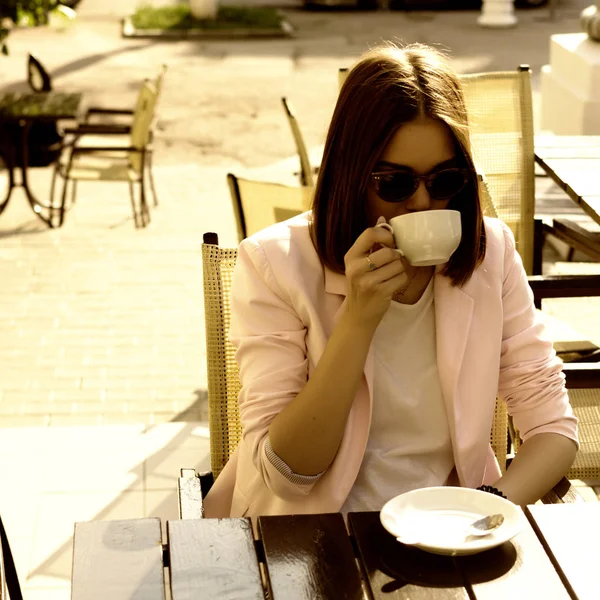 Genç güzel kız sıcak içecek, açık bir fincan içecekler