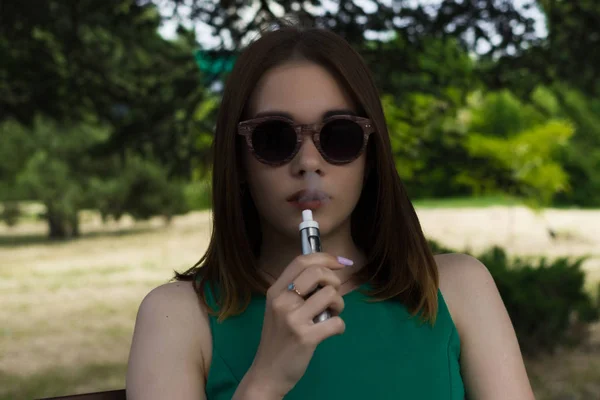 Młoda ładna kobieta pali elektroniczny papieros Obrazy Stockowe bez tantiem